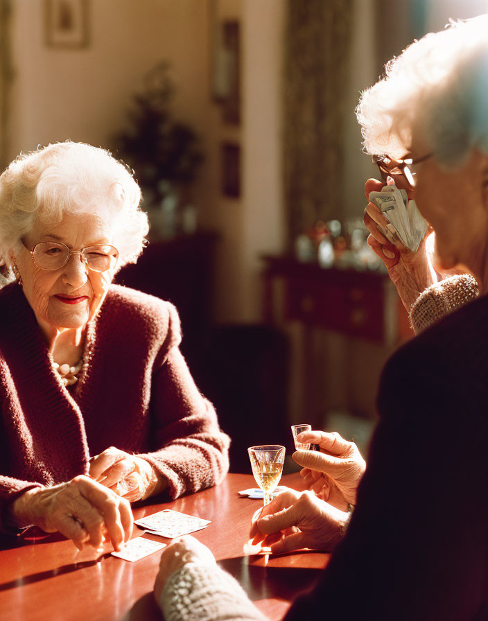 Elderly women playing cards and chatting indoors