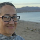 Surreal portrait of woman with round glasses and flower-adorned hair