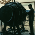 Businessman in suit with technology equipment and industrial backdrop.