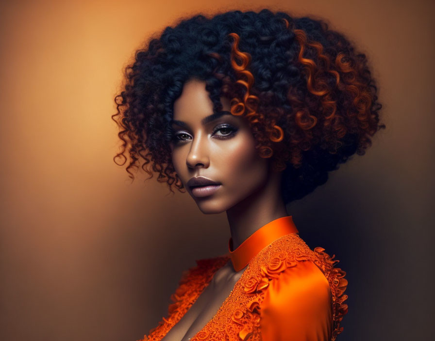 Portrait of woman with voluminous curly hair and striking eyes in ornate orange top.