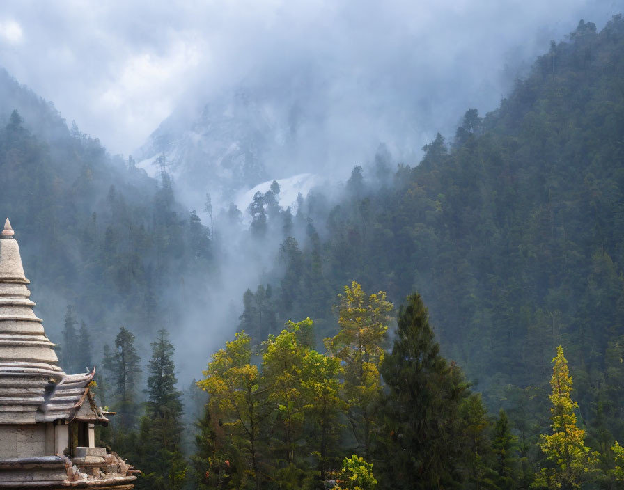 Tranquil mountain landscape with mist, temple, and snow-capped peaks