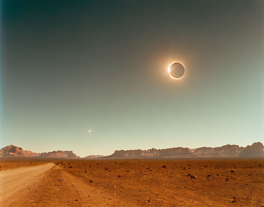 Natural phenomenon: Solar eclipse above desert with mountain silhouettes