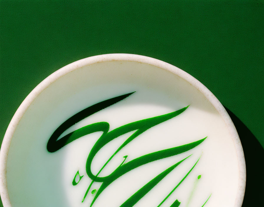 Green and White Artful Design Ceramic Bowl on Dark Green Background