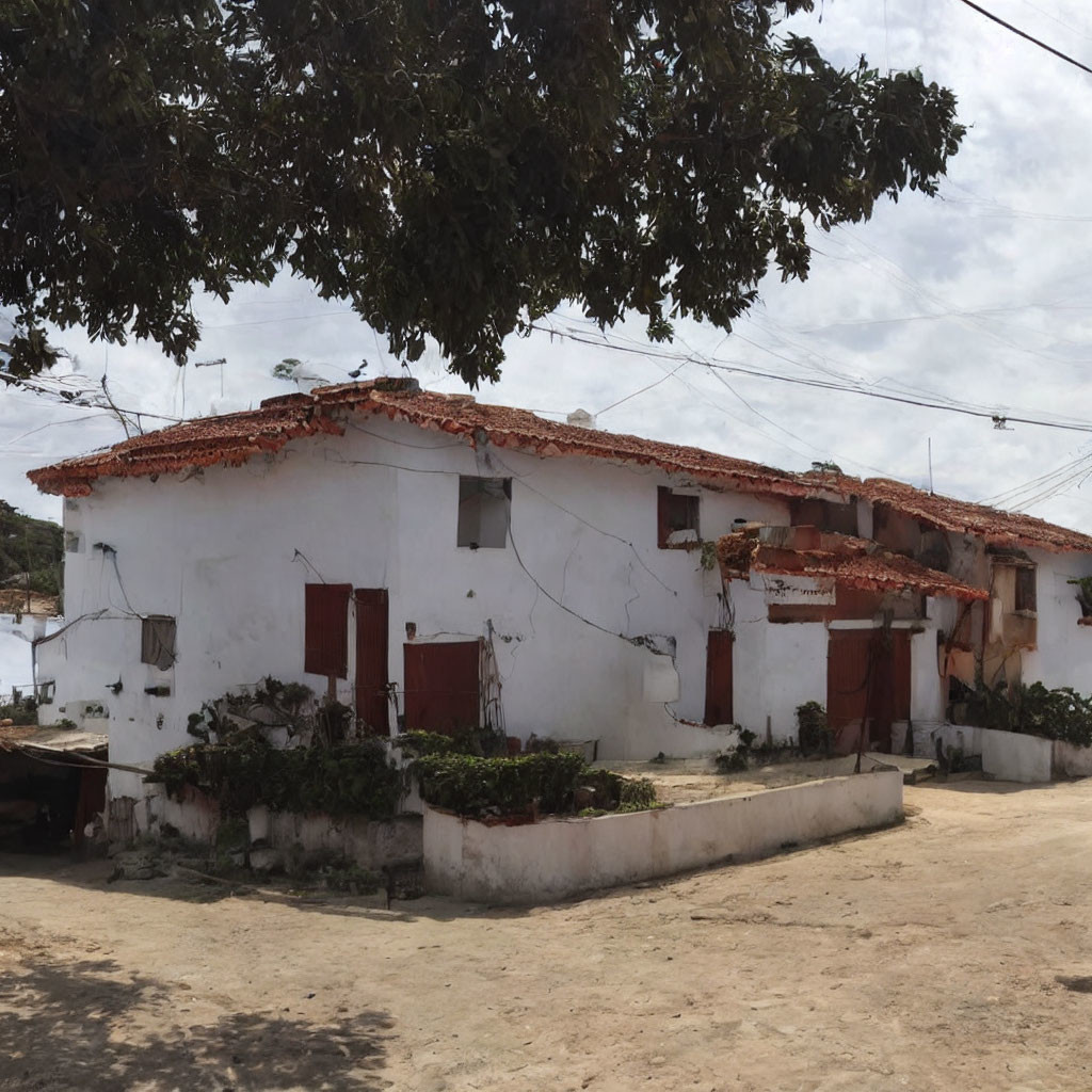 Traditional white houses with red roofs under cloudy sky