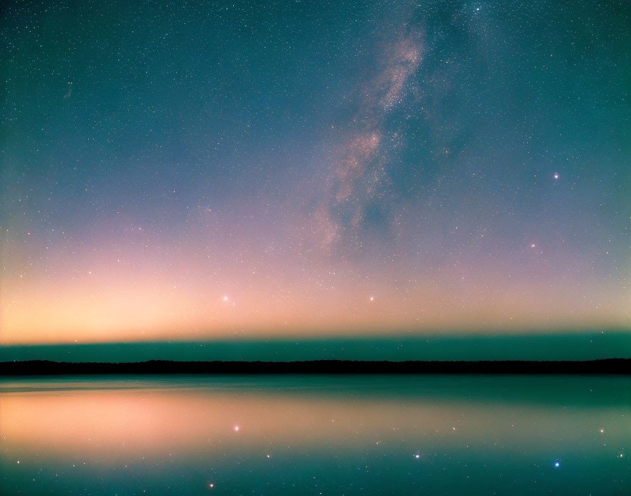 Serene lake under Milky Way in twilight reflection.