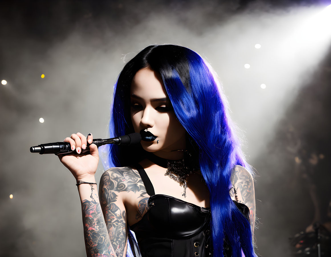 Blue and black hair woman with tattoos and corset holding a microphone on smokey stage