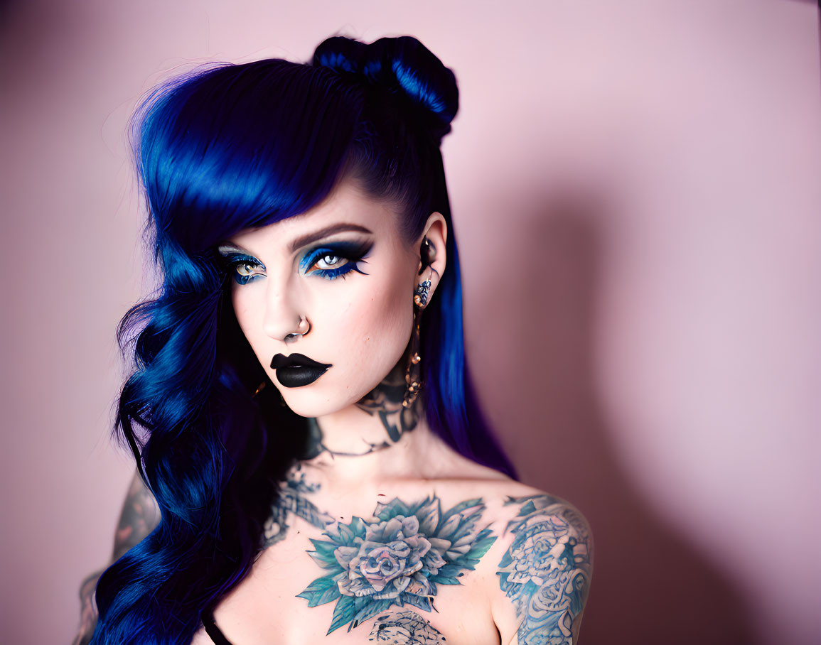 Vibrant blue hair and tattoos on a person against a pink background