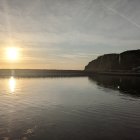 Serene Dawn Landscape with Calm Water and Soft Clouds