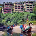 Tropical beach scene with multi-tiered buildings and boats