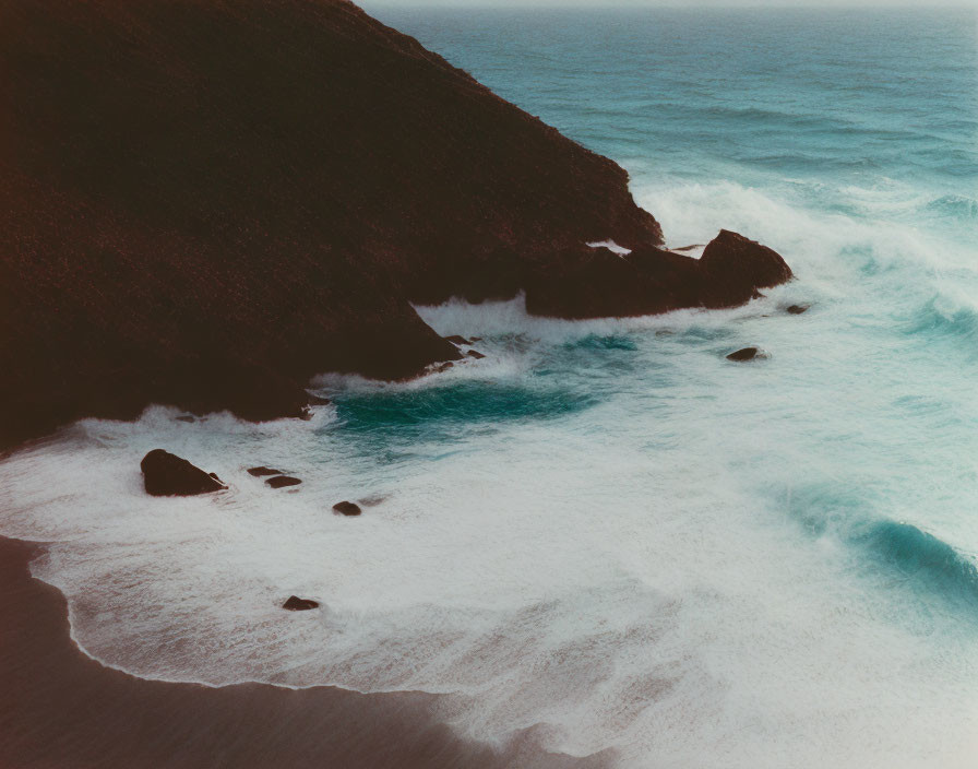 Scenic aerial view of rugged coastline with crashing waves