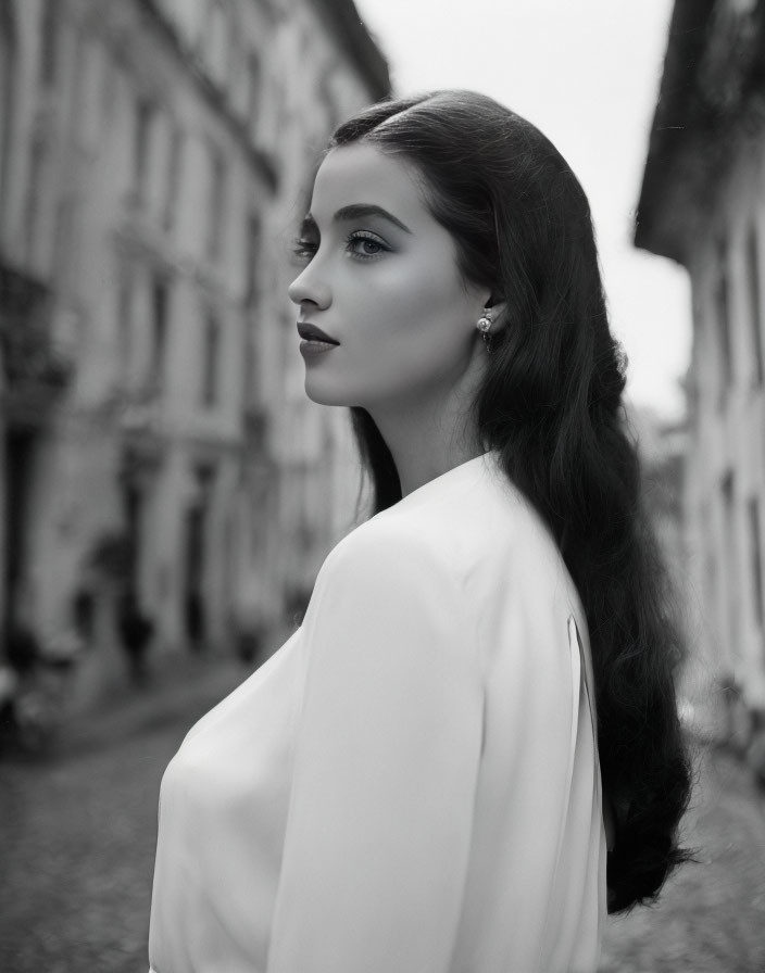 Monochrome portrait of woman in white blouse with long hair.