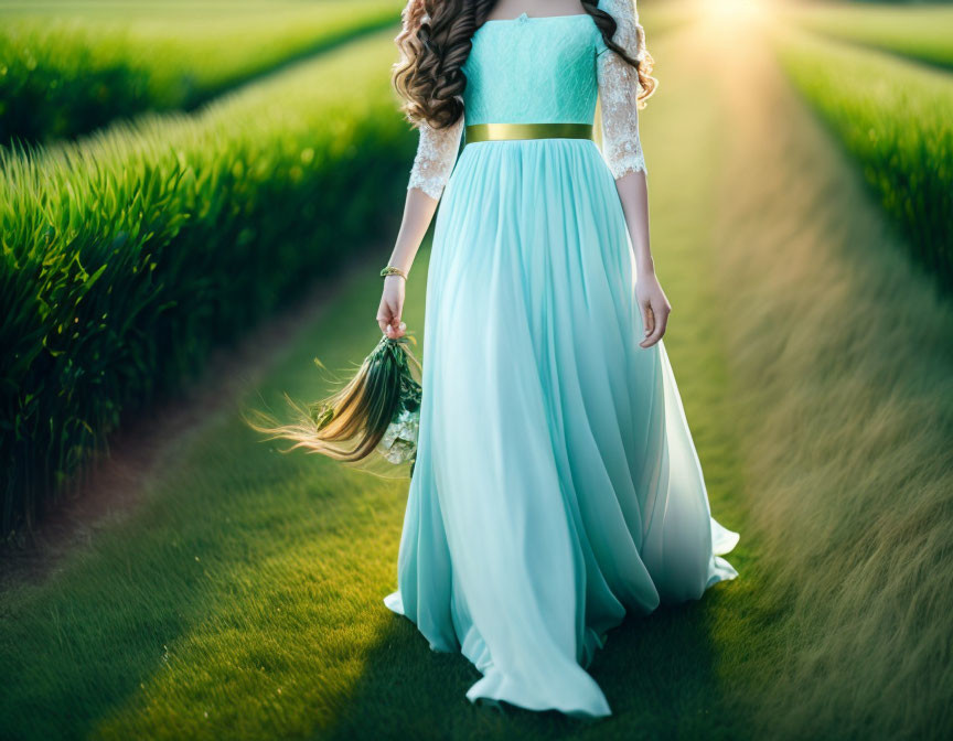 Woman in Turquoise Dress with Bouquet Walking Down Grass Aisle at Sunset