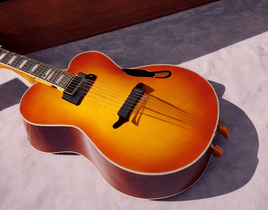 Sunlit acoustic guitar with sunburst finish on textured surface