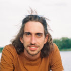 Man with Wavy Hair and Blue Eyes in Tan Overcoat Outdoors