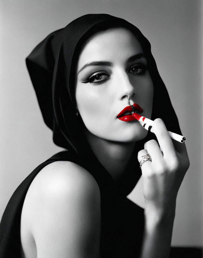 Monochromatic portrait of woman with headscarf, red lipstick, and striped cigarette