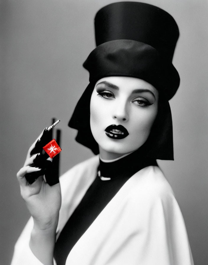 Monochrome image of woman with dramatic makeup and top hat holding a cigarette