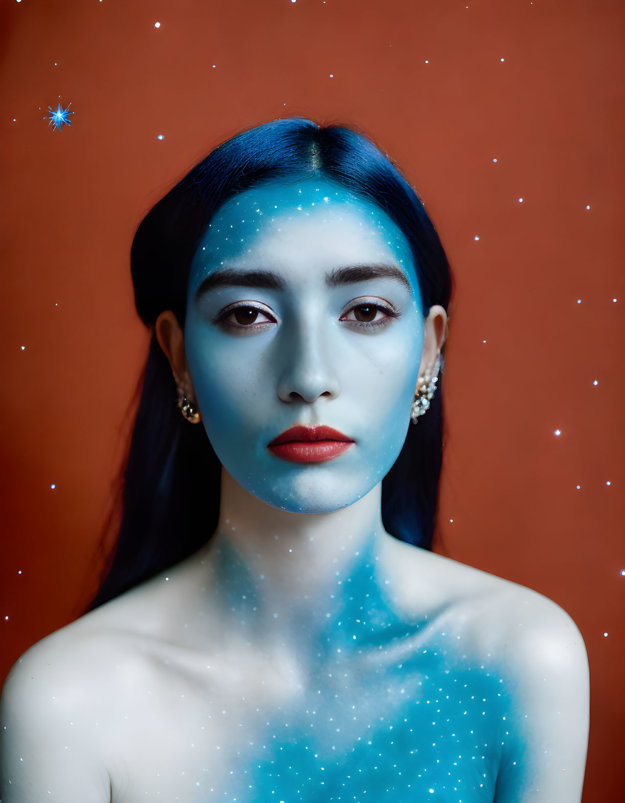 Blue-painted woman with starry skin on red backdrop gazes at camera