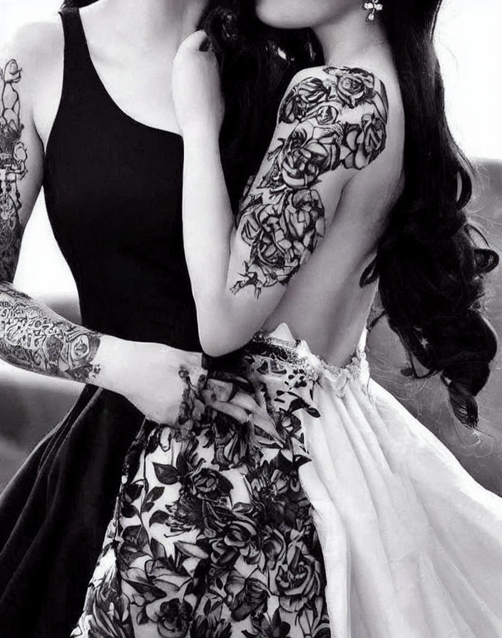 Intimate portrait of two people embracing with sleeve tattoos and floral dress