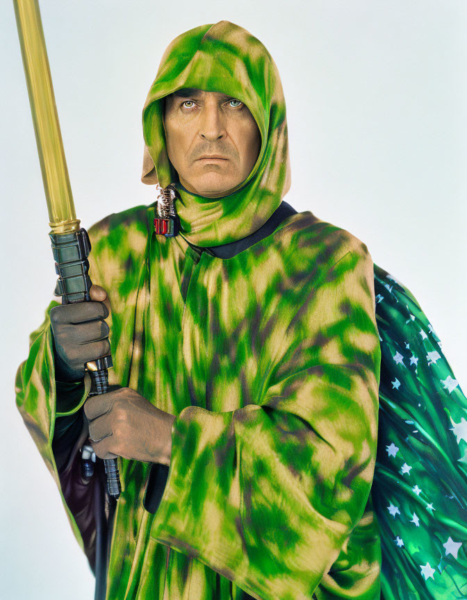 Camouflage cloaked person with lightsaber and serious expression