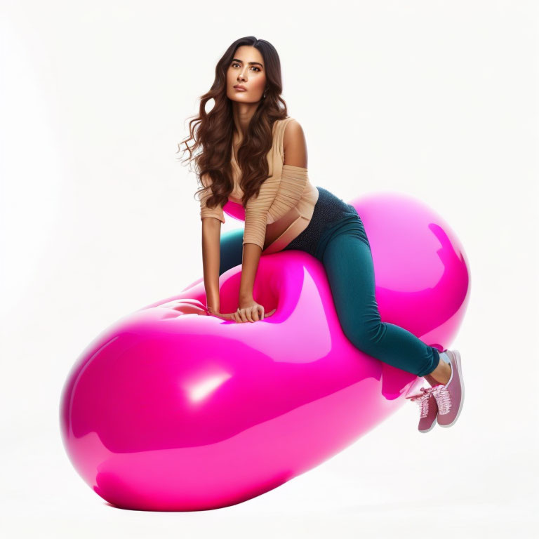 Woman sitting on pink oversized musical note in green pants and beige top