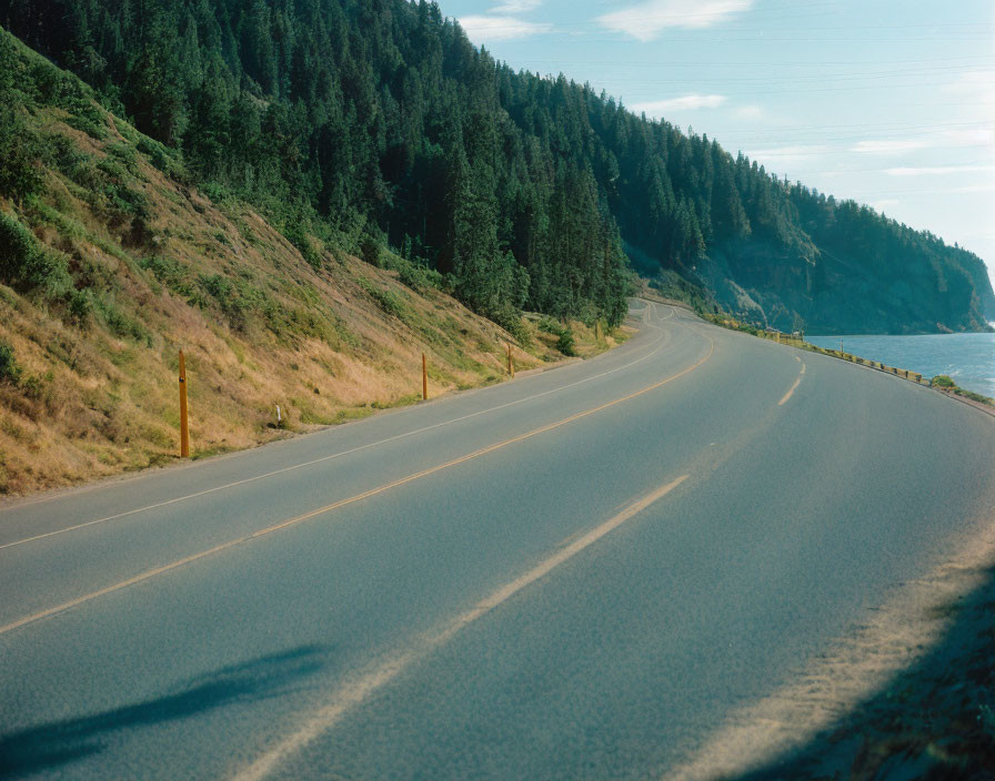 Scenic winding road through hilly landscape by calm sea