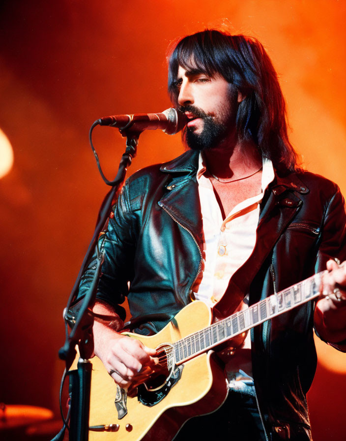 Bearded musician performing with electric guitar on stage