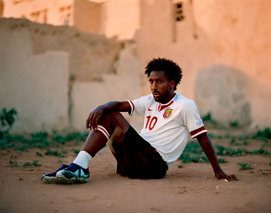 Soccer player in number 10 jersey at dusk with sandy buildings