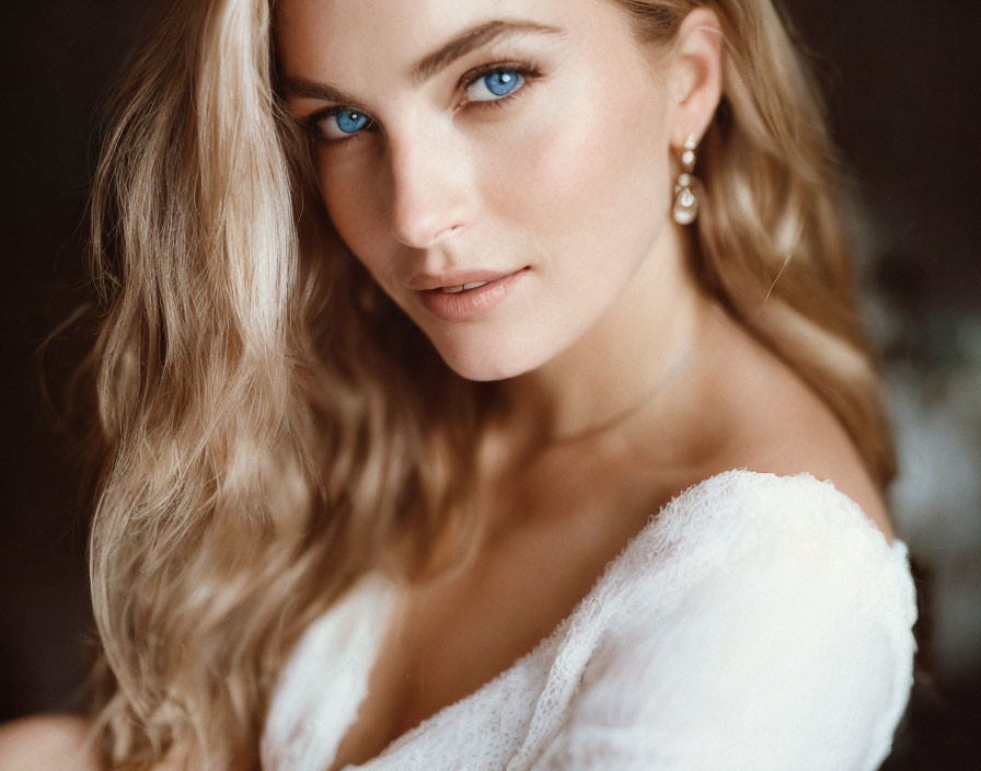 Portrait of woman with blue eyes and blonde hair in white outfit