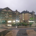 Picturesque riverside village with illuminated buildings and serene water reflections.