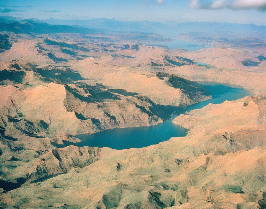 Rugged Terrain with Valleys and River on Clear Sky