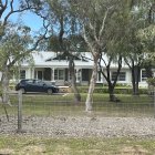 White Countryside House Surrounded by Gardens and Blooming Flowers