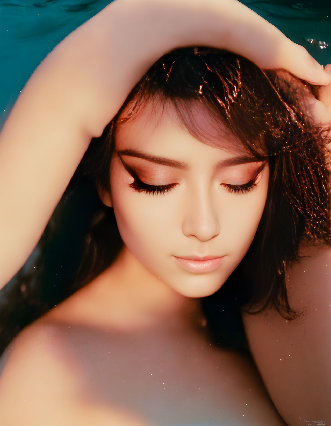 Woman with Eyes Closed Immersed in Warm Light Water