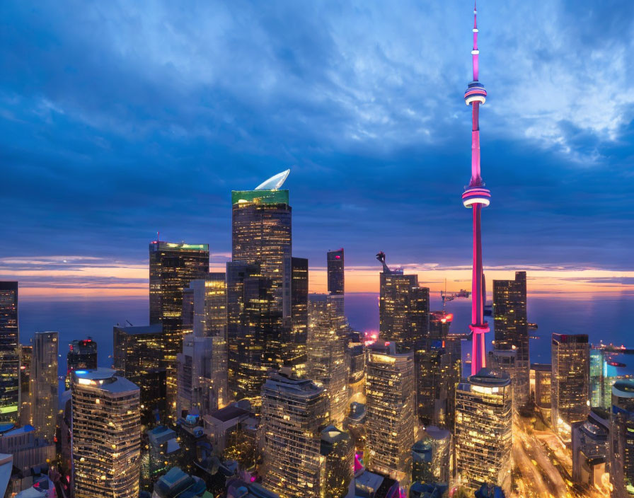 Twilight view of Toronto skyline with pink illuminated CN Tower and city lights on skyscrapers