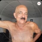 Muscular shirtless elder man with white mustache outdoors