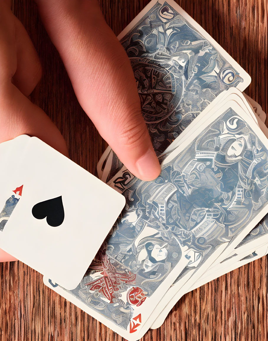 Intricately designed playing cards shuffled on wooden surface