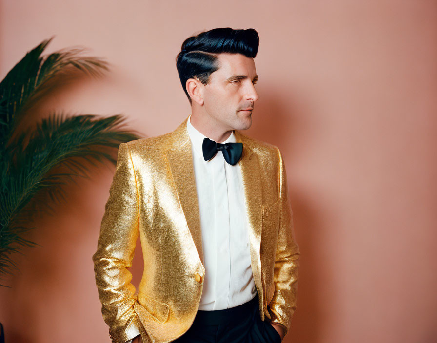 Man in Golden Jacket and Bow Tie on Peach Background with Plant