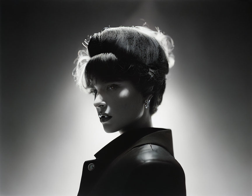 Monochrome portrait of person with high hairdo and dramatic backlighting