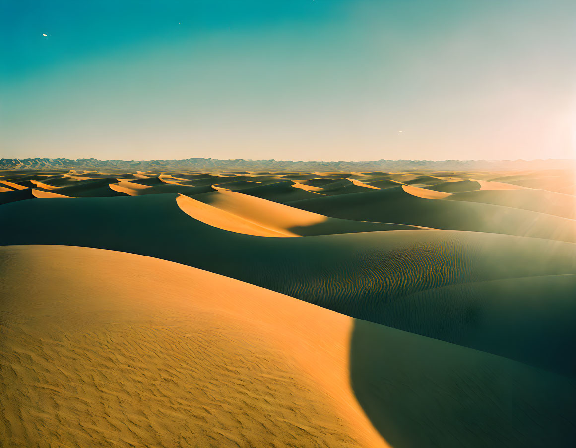 Radiant sunrise over golden sand dunes in clear desert sky