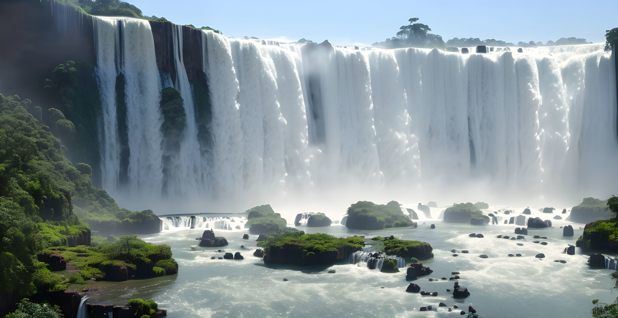 Majestic waterfall cascading into river amid lush greenery