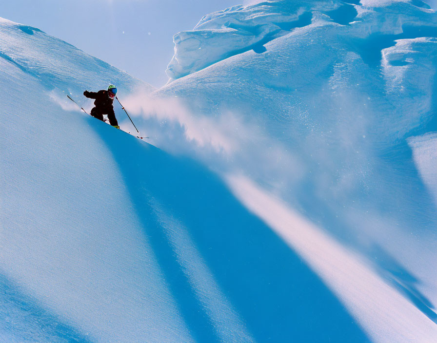 Skier carving through snow on sunlit icy mountainside