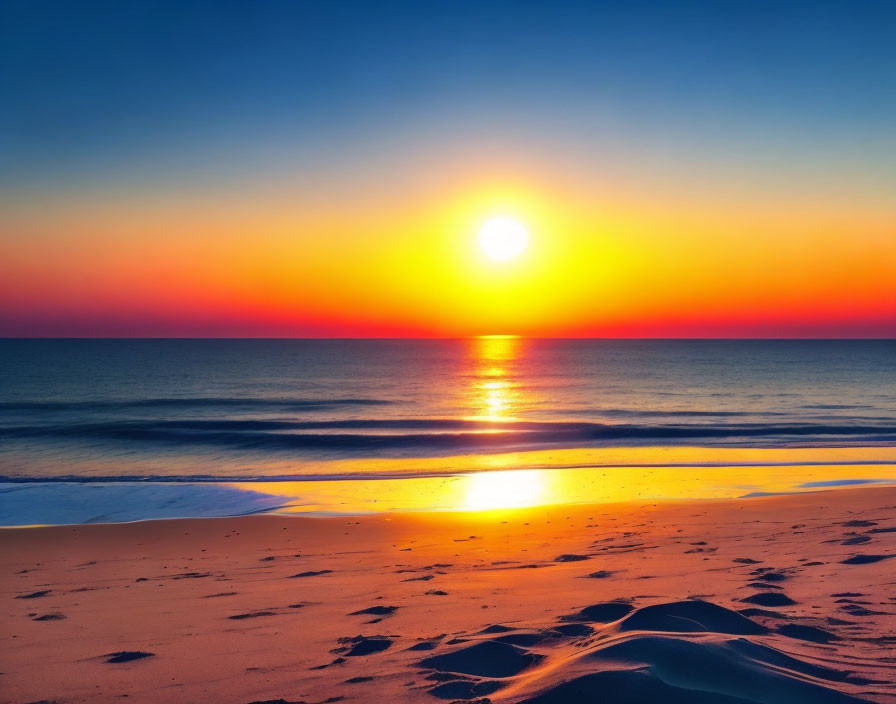 Scenic beach sunset with orange and blue sky reflecting on ocean.