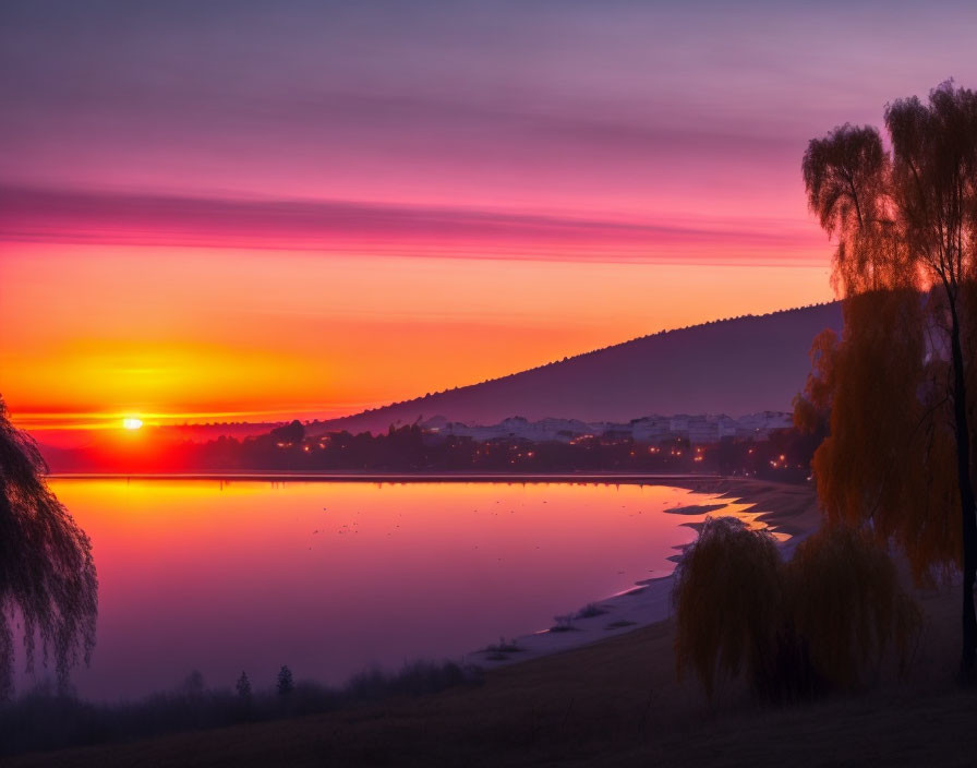 Tranquil sunset over calm lake with purple and orange skies reflecting on water