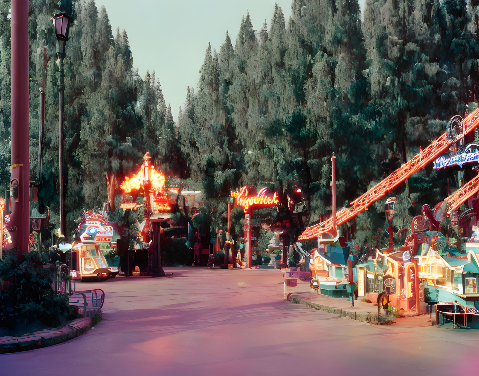 Deserted theme park street with neon signs and rollercoaster tracks