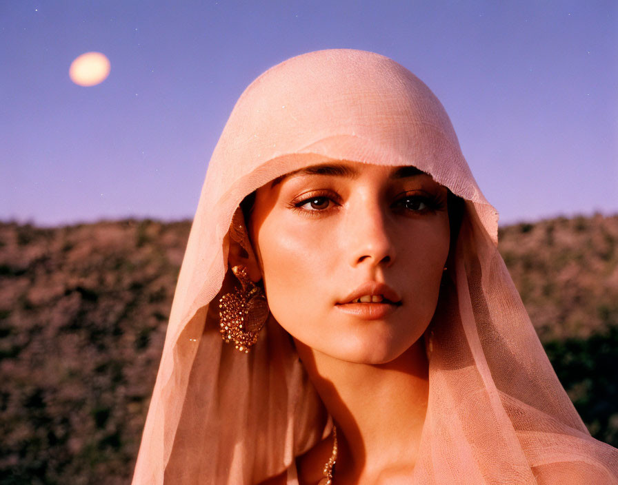 Woman in Pink Veil with Golden Earrings Against Twilight Sky