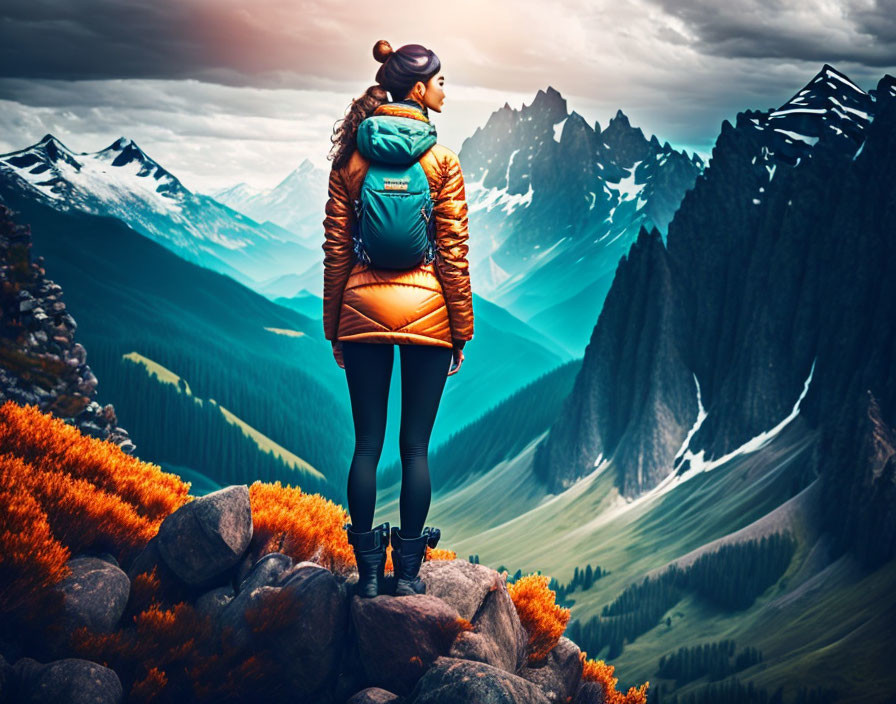 Person in orange jacket admiring snowy mountain landscape