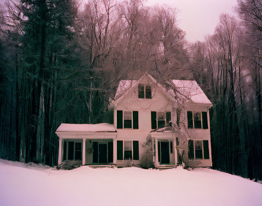 Snow-covered white house with green shutters in winter scene