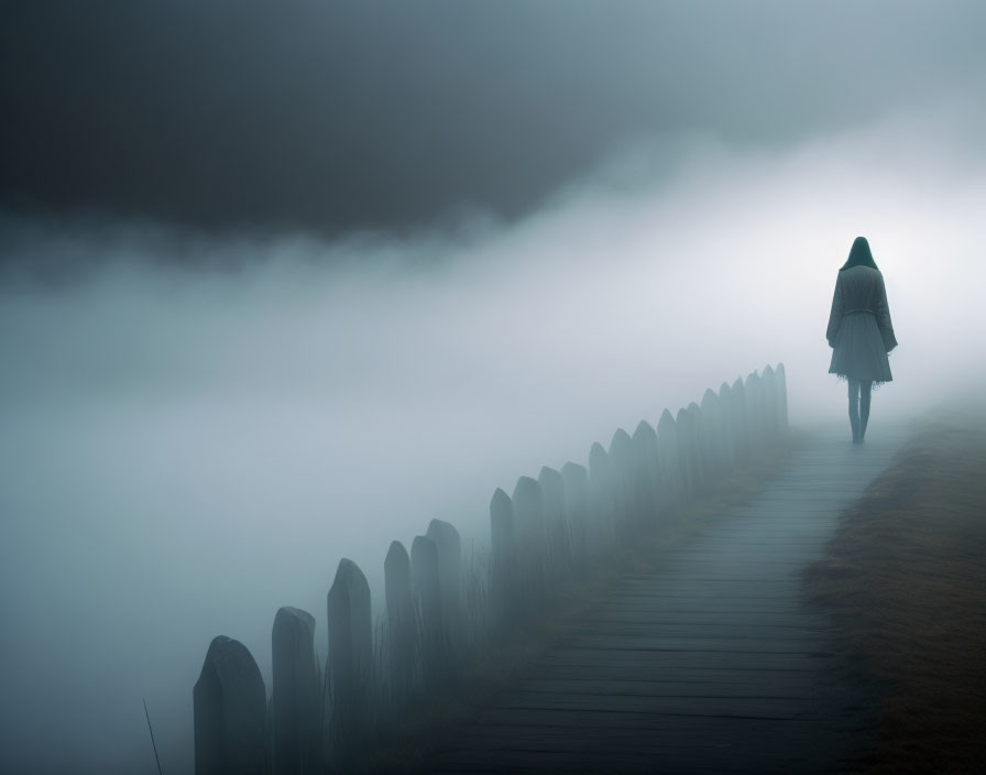 Solitary figure walking on misty boardwalk by fence posts