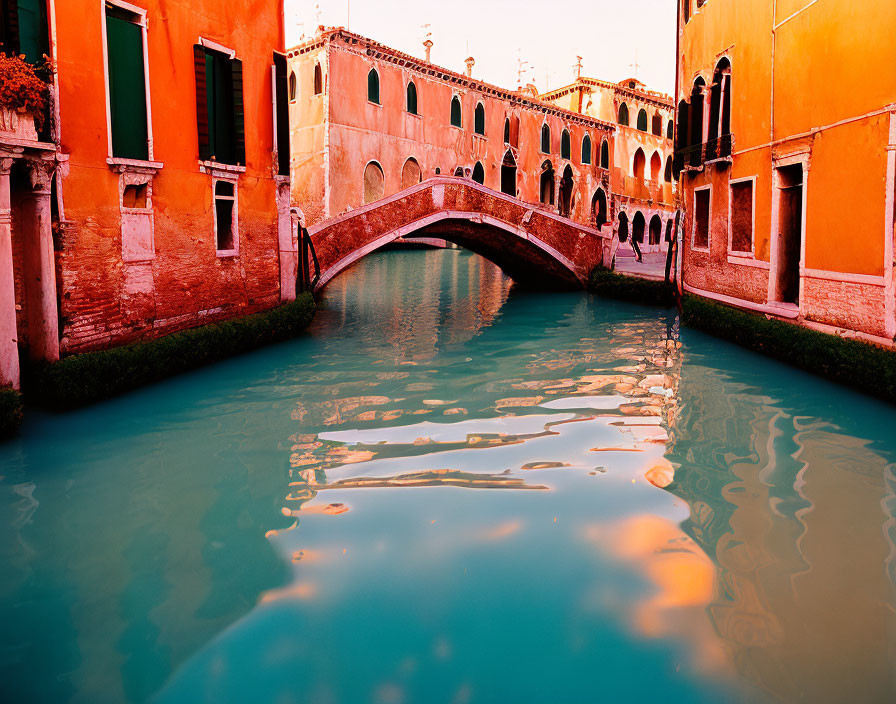 Venetian canal with stone bridge and historical buildings.