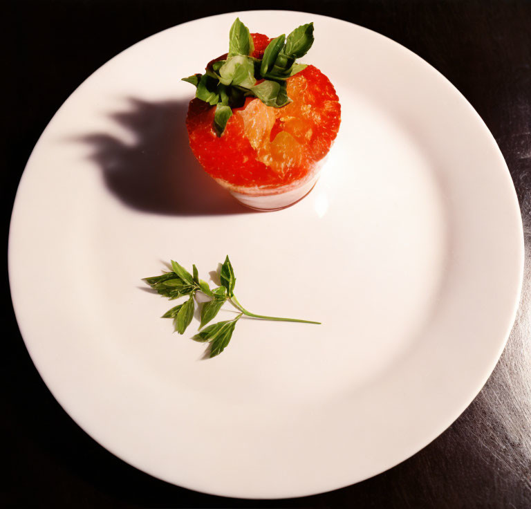 Fresh grapefruit with basil on white plate for serving.