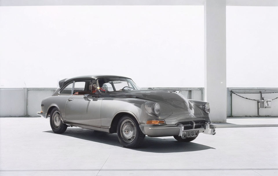 Vintage Silver Car with White-Wall Tires in Minimalistic White Parking Structure